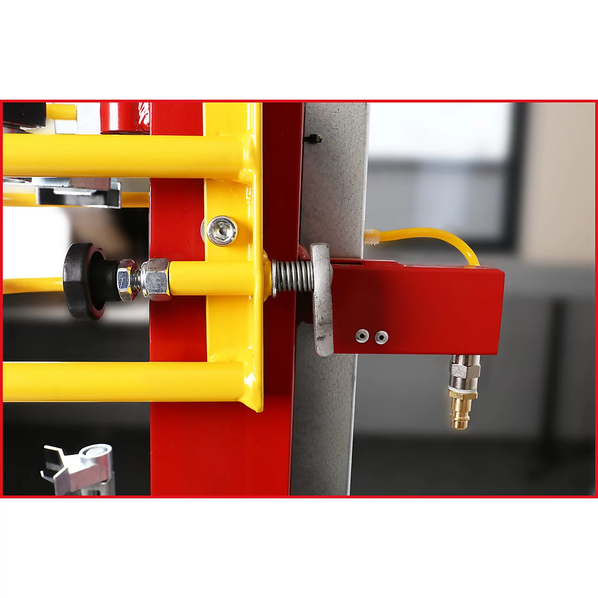 Detailaufnahme einer rot-gelben Metallkonstruktion mit Schrauben und Anschlüssen.